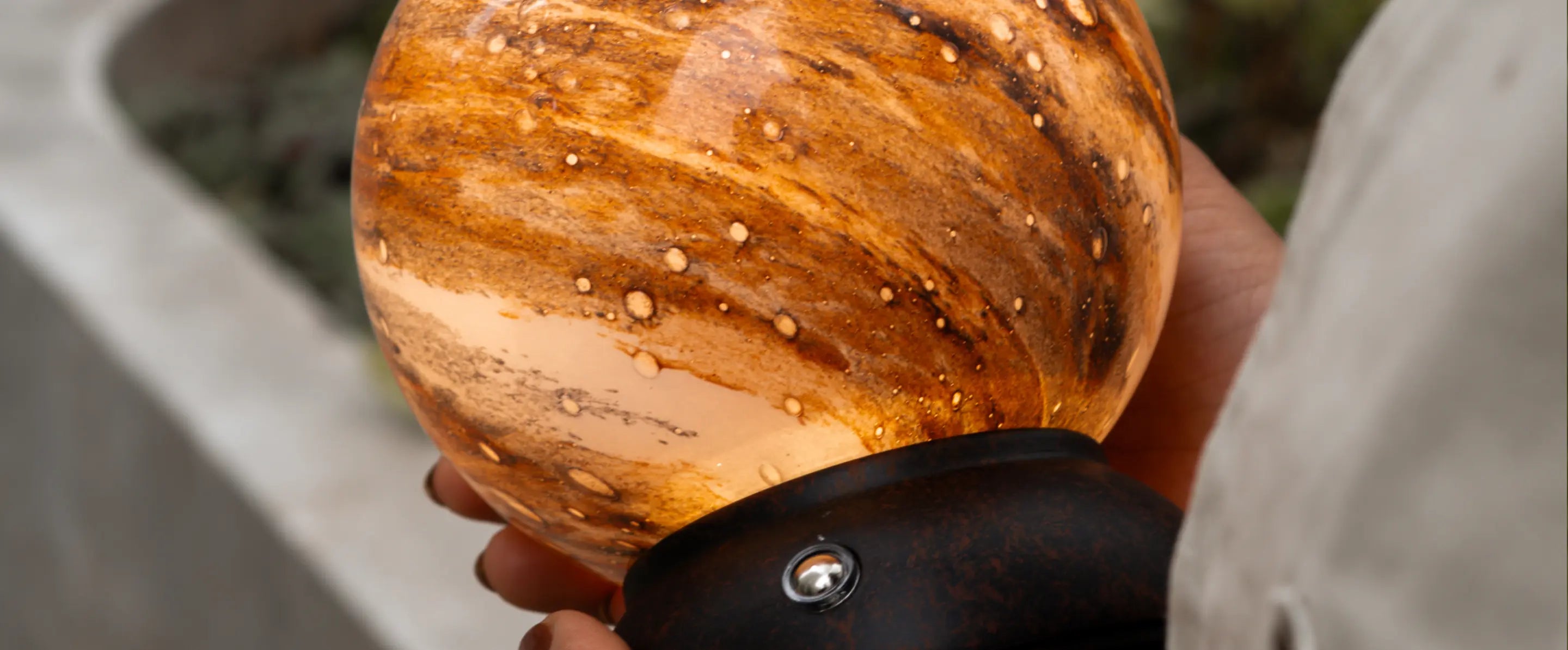 Close-up of Cosmo glass table lamp showing its planet-inspired textured shade