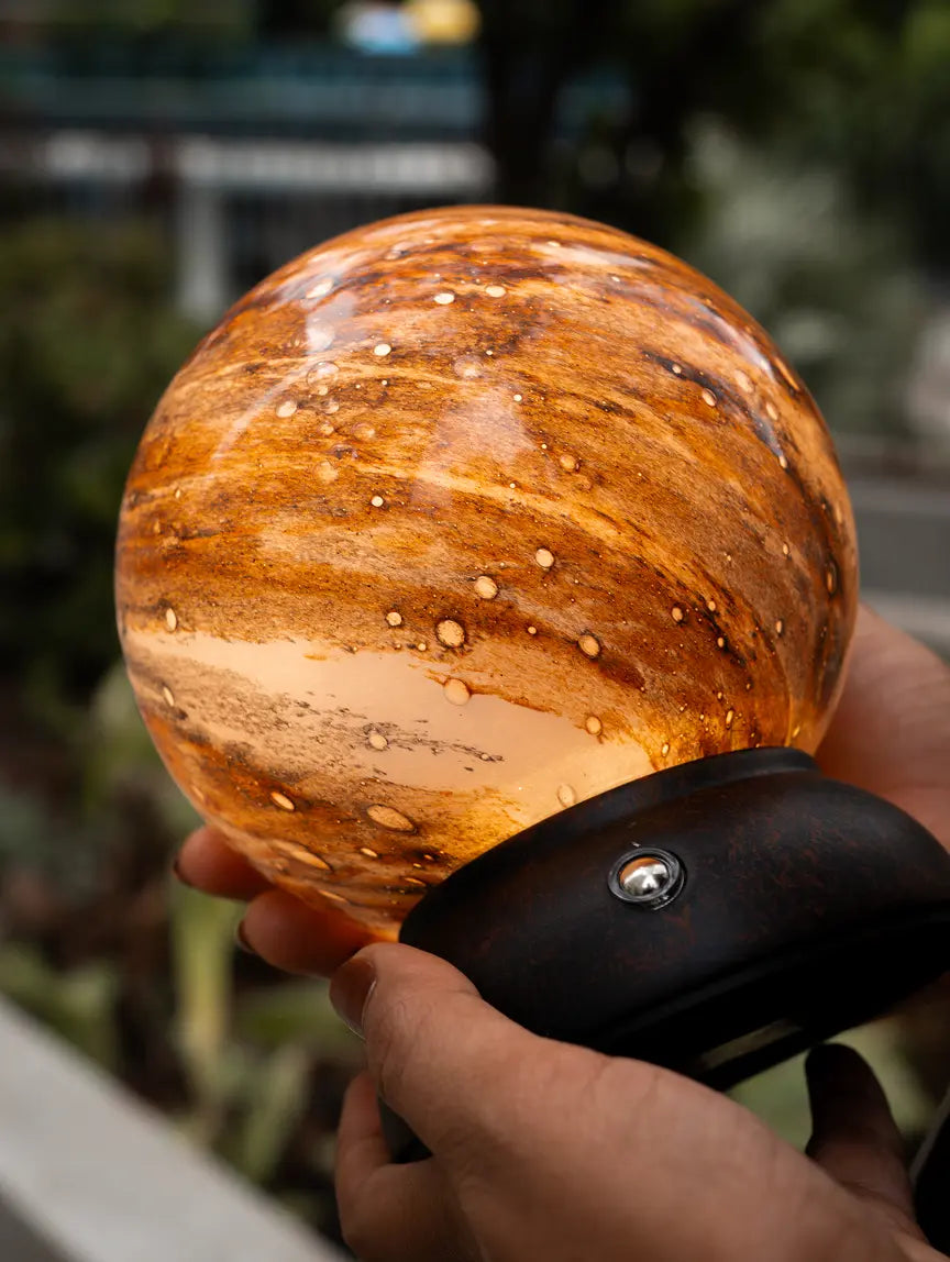 Close-up of Cosmo portable lamp with warm glow and textured glass shade