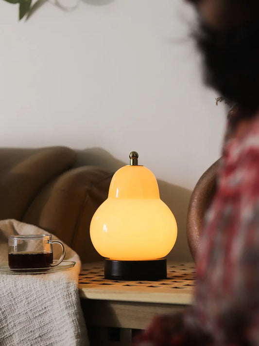 Gharko Pear Table Lamp with warm light styled on a side table in a cozy living room