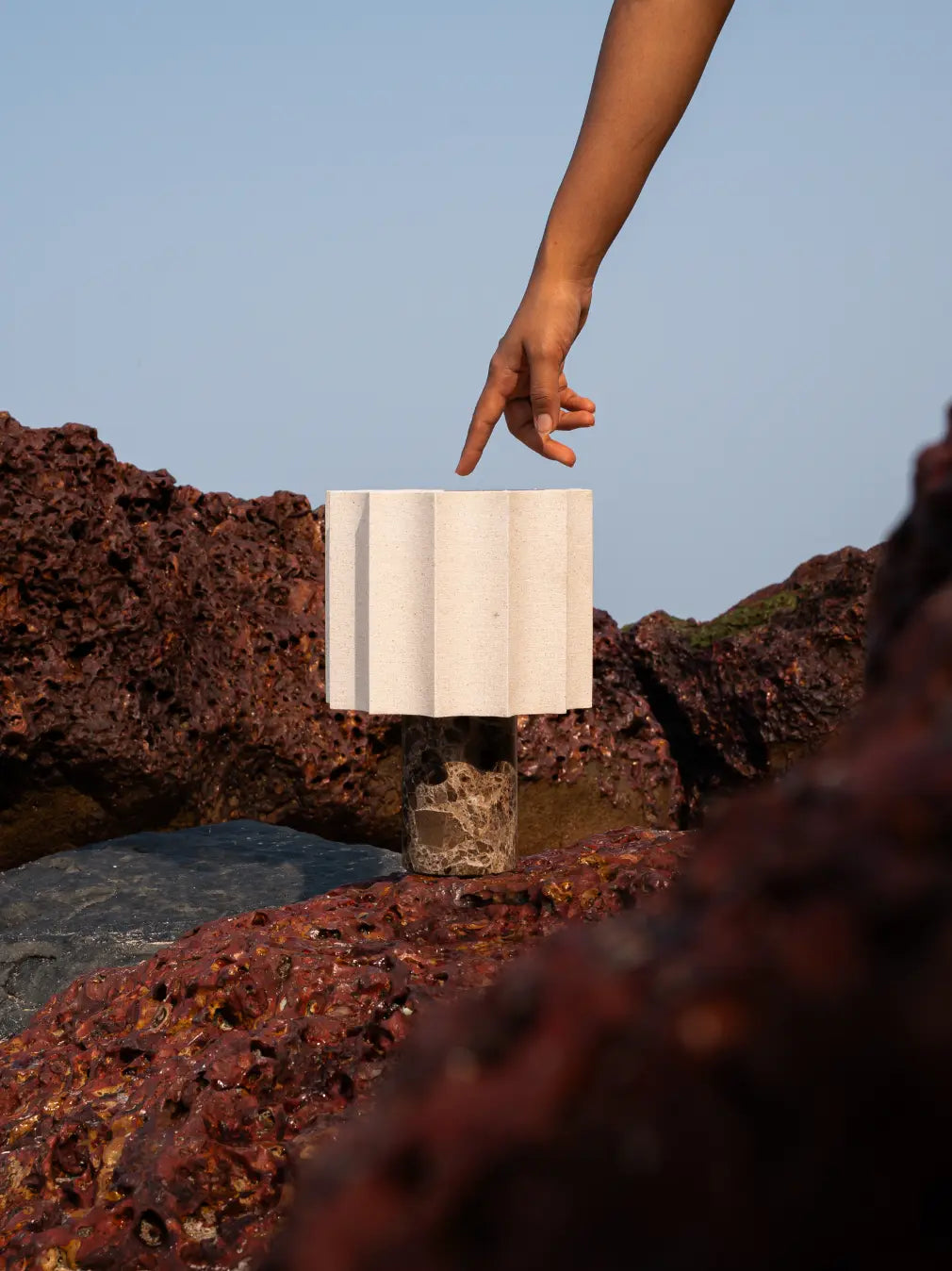 Hand reaching for the top touch control on the Haze Mocha Marble Portable Table Lamp