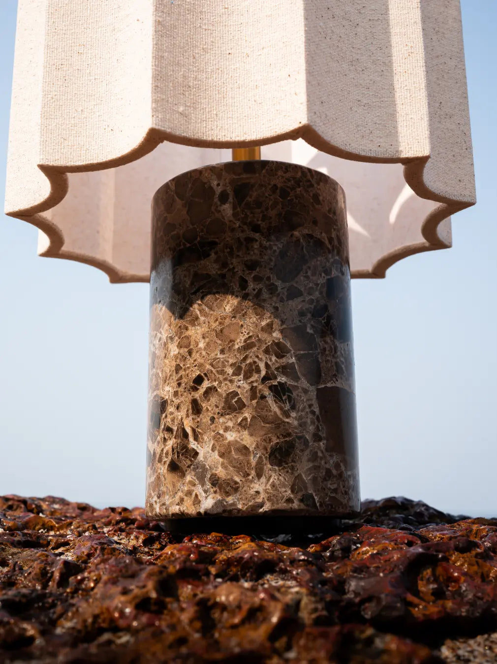 Close-up of Haze Mocha table lamp’s veined matte marble base and scalloped fabric shade