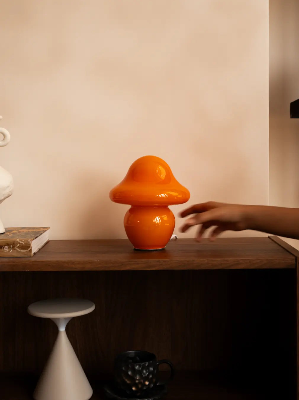 Mini orange mushroom glass table lamp styled on a wooden console