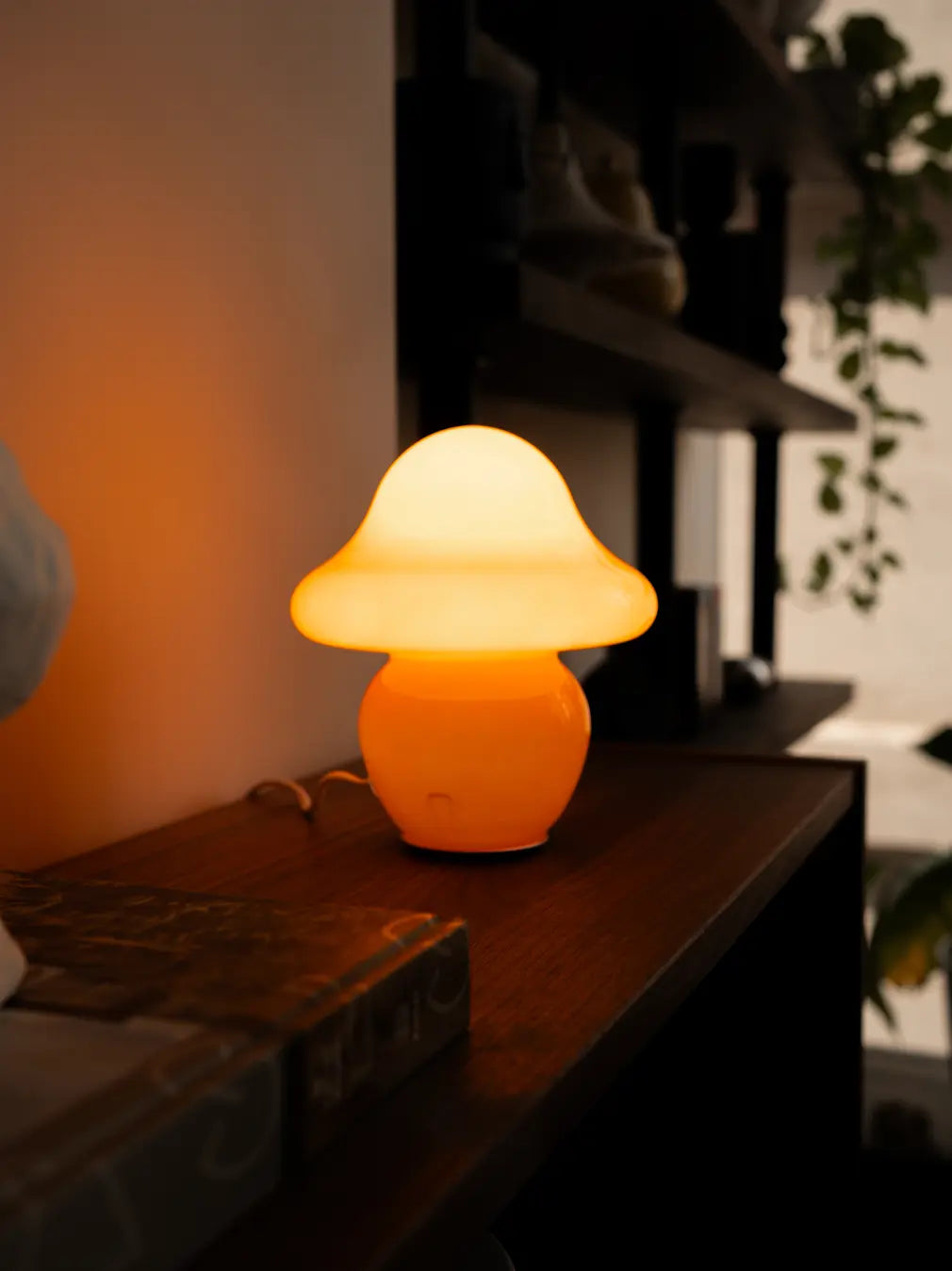 Orange mushroom table lamp casting a warm ambient glow in a modern interior