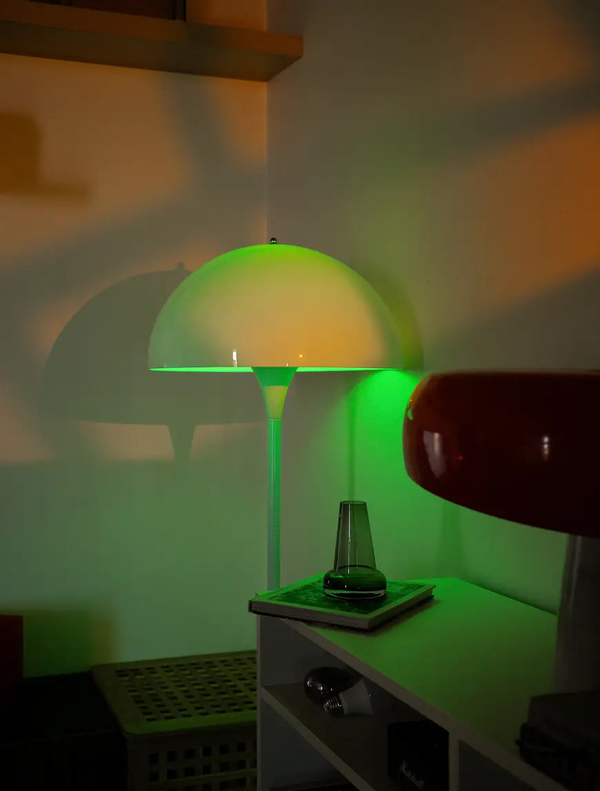 Nova white floor lamp casting green ambient light beside a cabinet