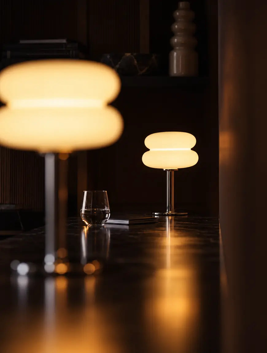 Orbit yellow glass table lamps casting warm light shadow across a dark lounge table.