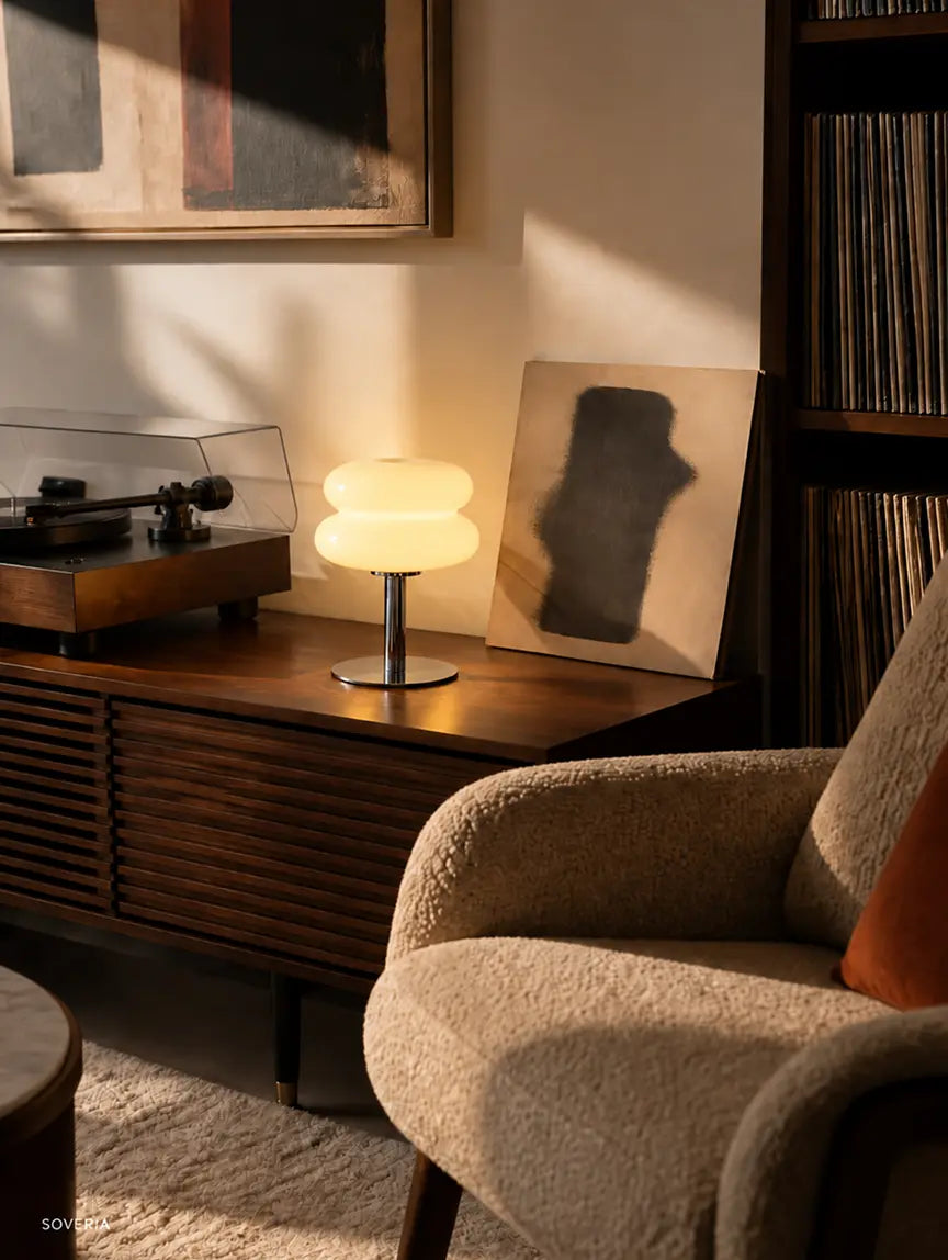 Orbit yellow glass table lamp on a living room console beside a record player.