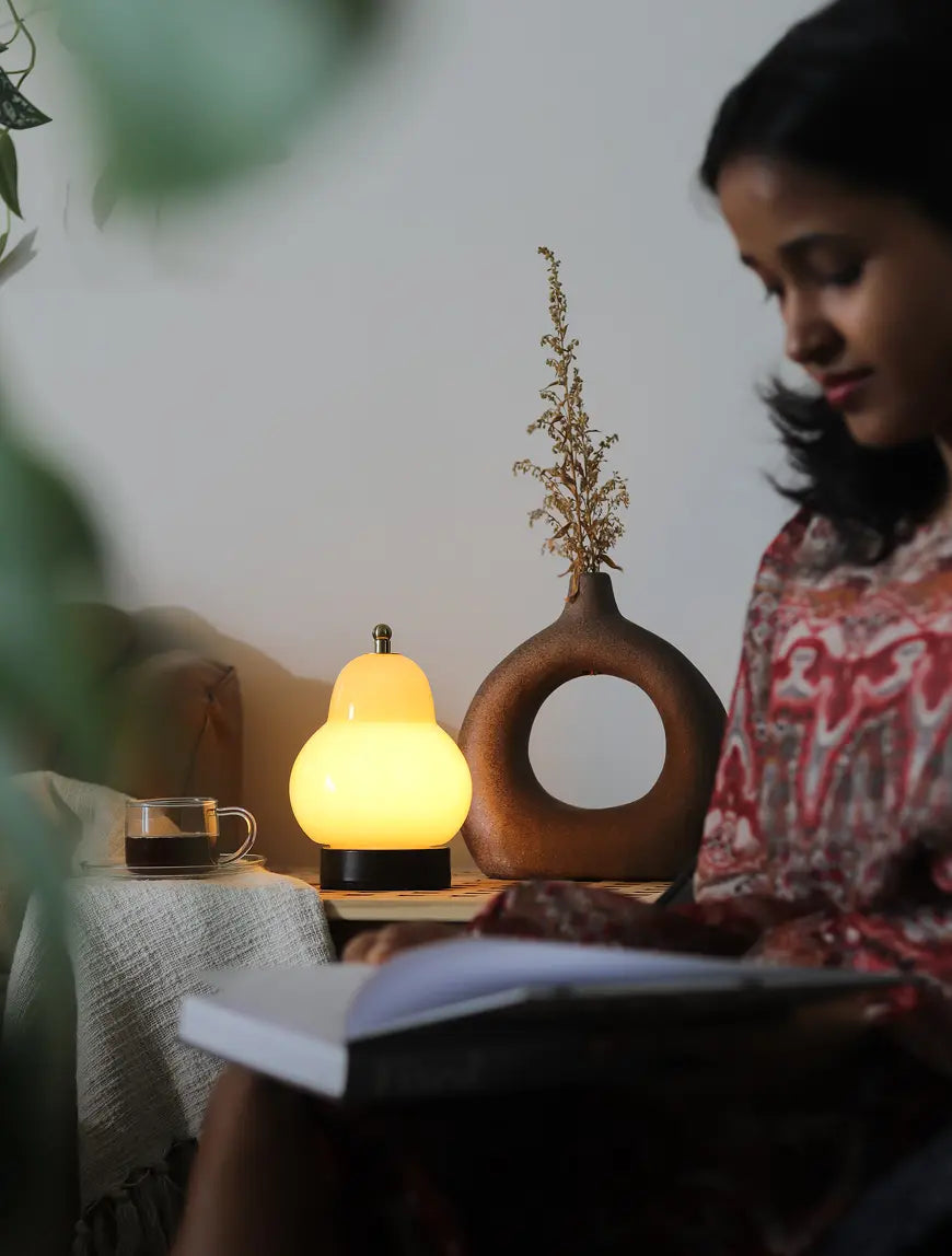 Pear Table Lamp creating soft ambient lighting beside a reading area