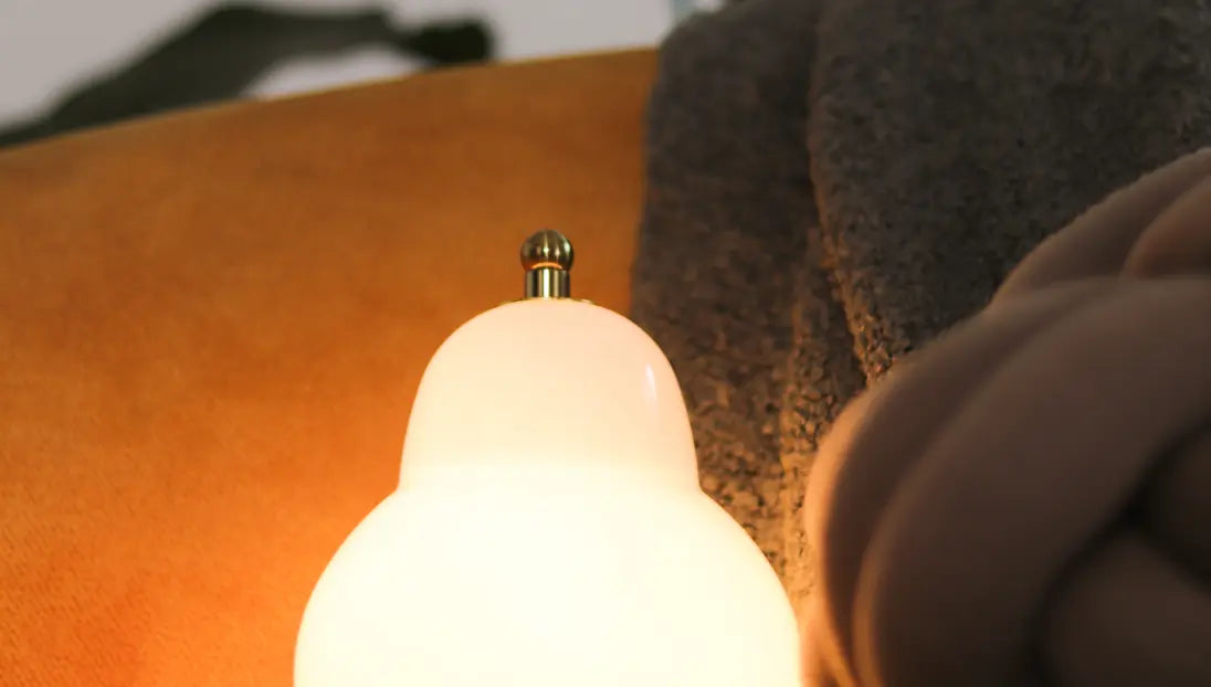 Pear Table Lamp casting a soft, glare-free warm glow through its glass shade