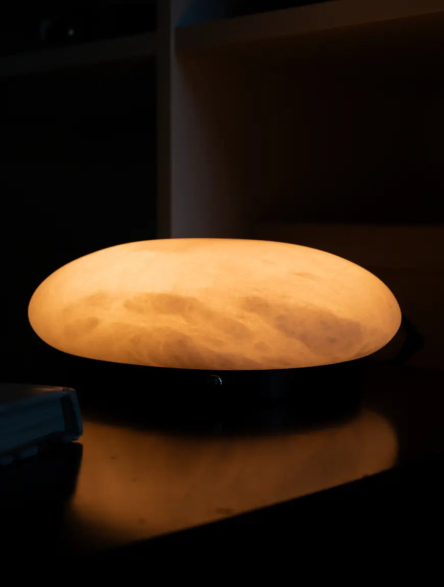 Pebble Marble Portable Table Lamp glowing warmly with visible natural marble veining