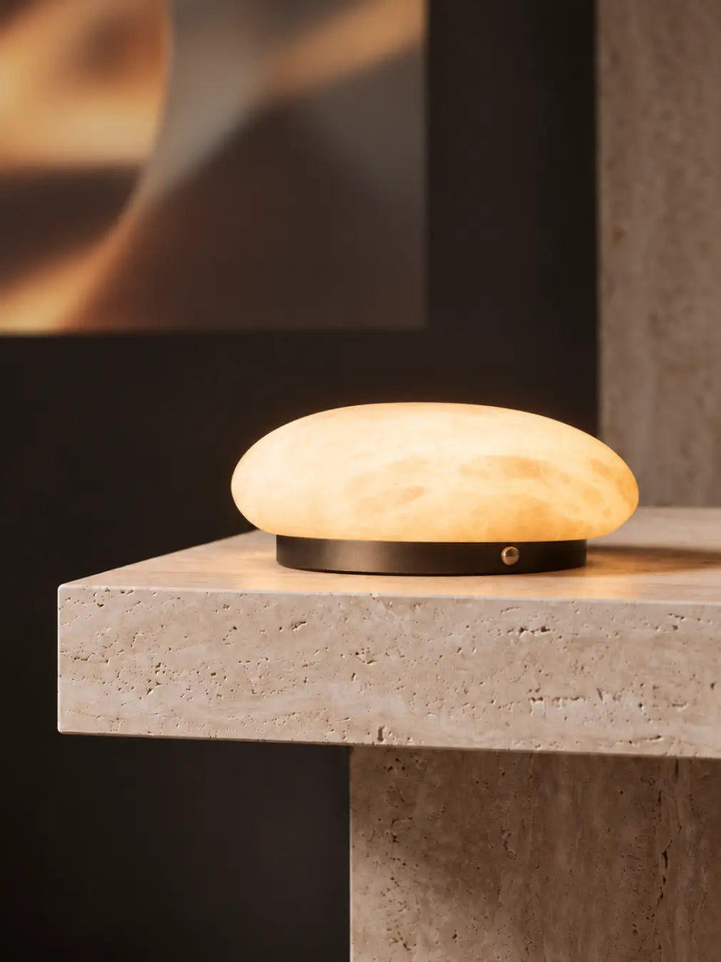 Pebble Marble Portable Table Lamp glowing warmly on a stone side table