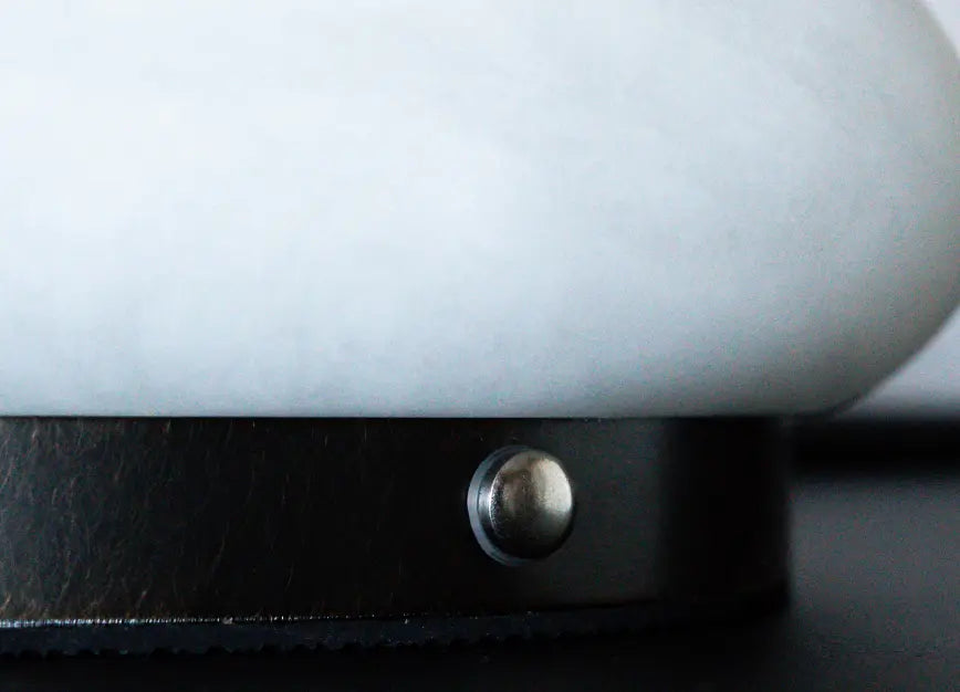 Close-up of Pebble Marble Portable Table Lamp touch switch on the black metal base