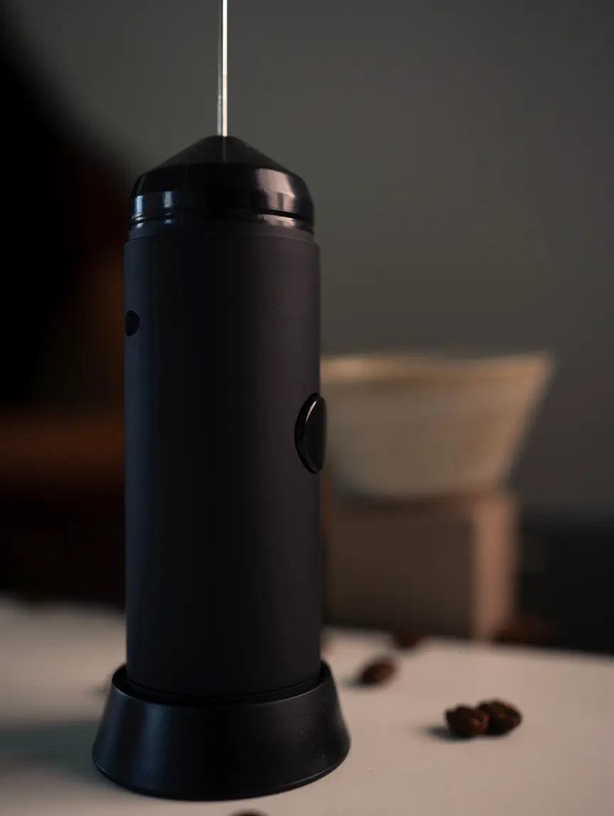 Sleek black Twist Milk Frother on lampstand base, showing compact modern design