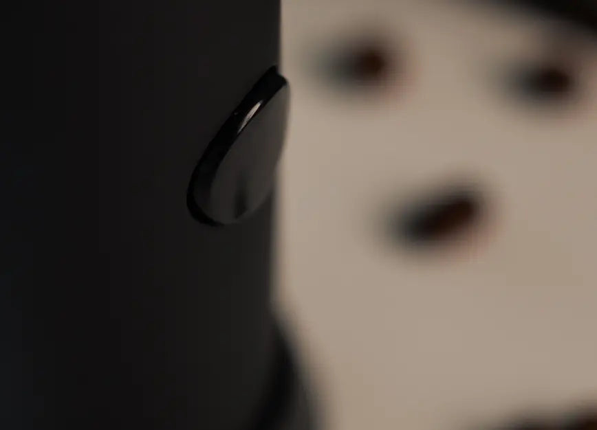 Power button on the Twist Milk Frother’s matte black body, showcasing its ergonomic and user-friendly design.