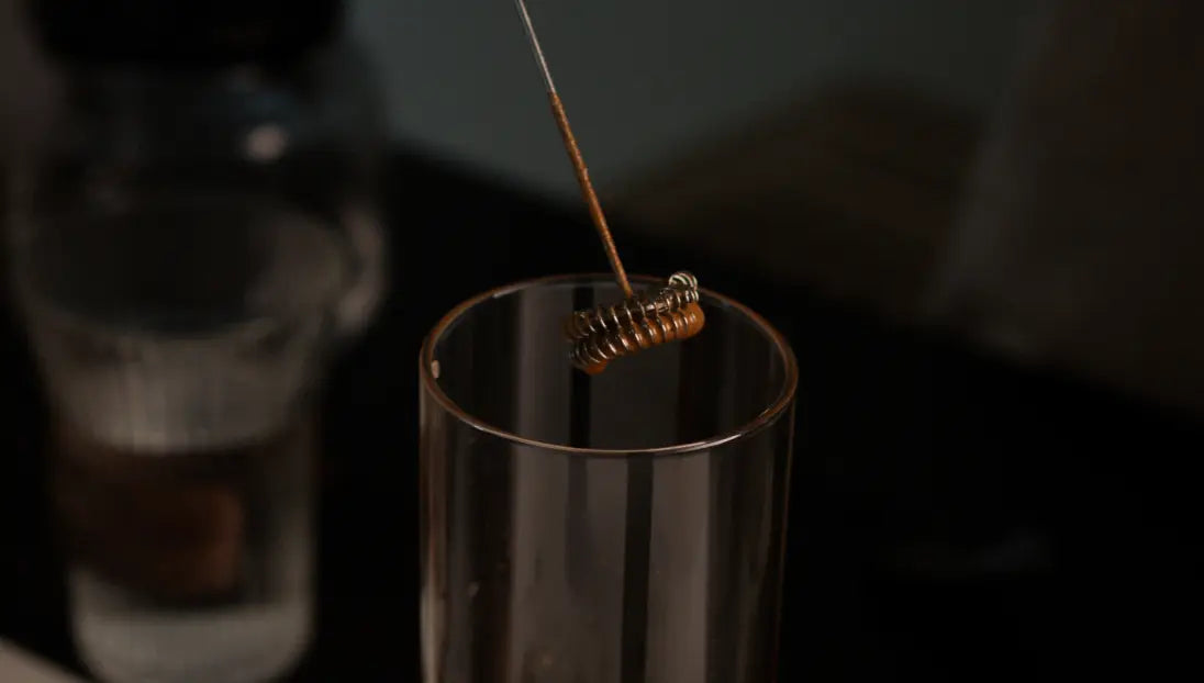Twist Milk Frother whisk submerged in a glass, showing its high-speed frothing capability.